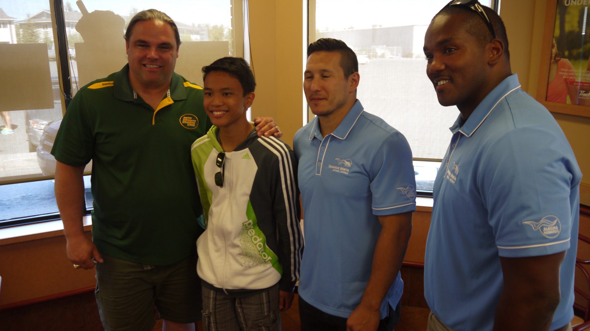 Jed Roberts, Rob Brown and Jordin Tootoo pose with a fan. 