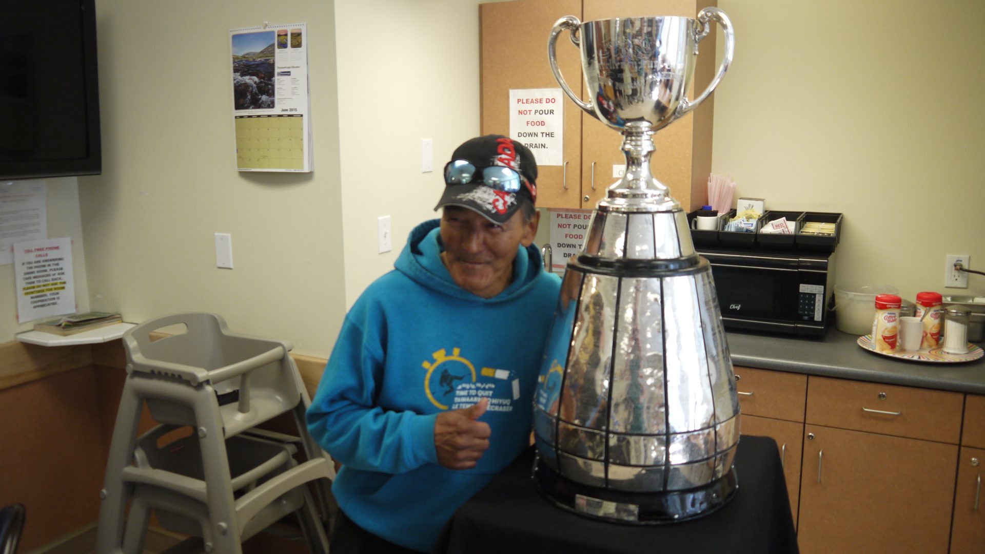 A fan poses with the Grey Cup at Larga Kitikmeot.