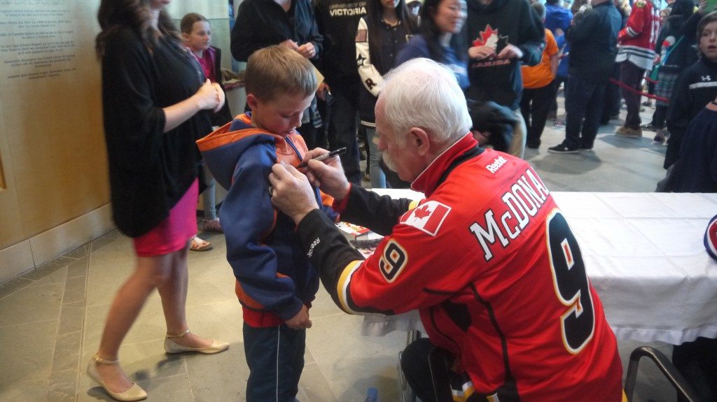 Lanny McDonald signing a young fans' Oilers sweater