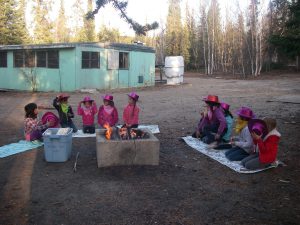 Girl guides sit around a campfire outside the cabin in 2012.